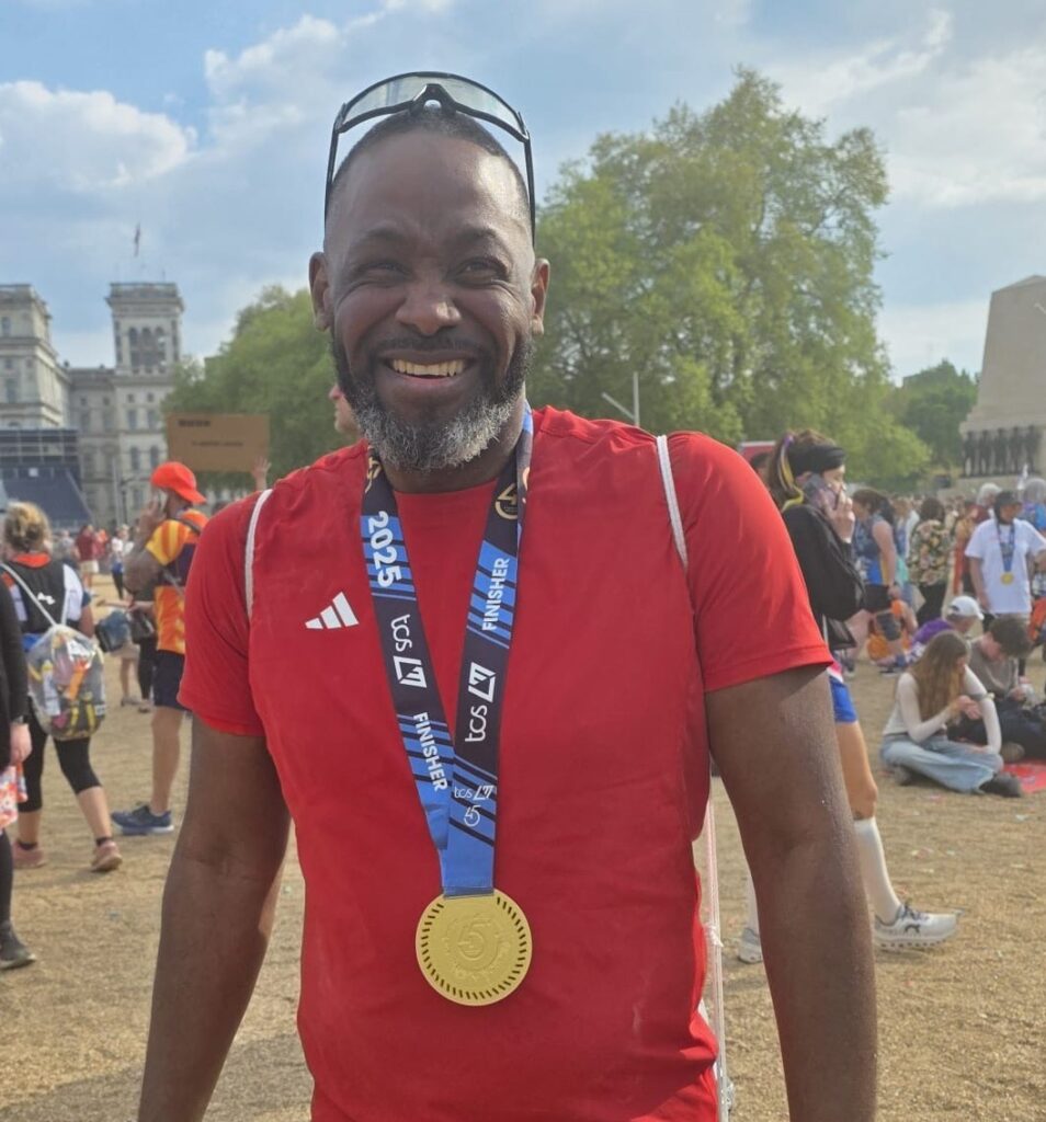 Network for Africa's London Marathon runner with his medal at the end of the run.